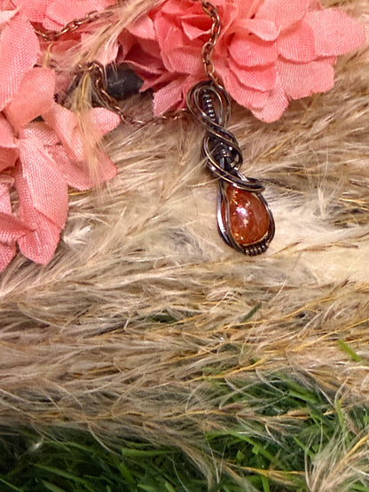 Sunstone pendant wrapped in oxidized copper