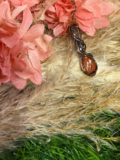 Sunstone pendant wrapped in oxidized copper