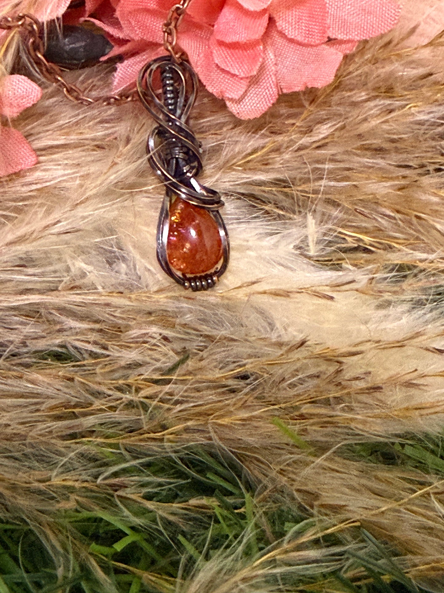 Sunstone pendant wrapped in oxidized copper
